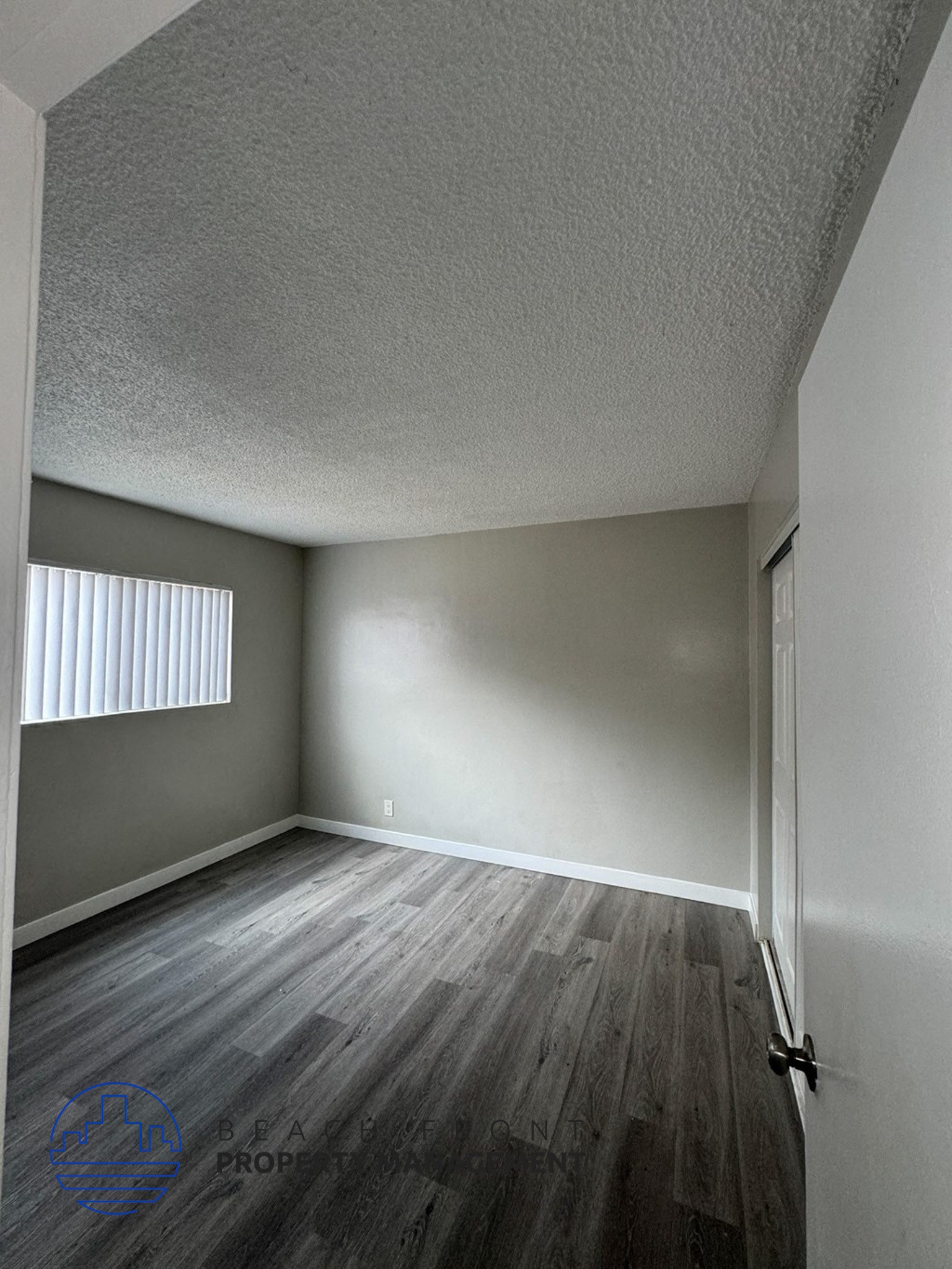 an empty room with wood floors and a window